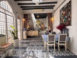 A dining area with a patterned floor, a chandelier, and a view of the kitchen. - A colorful Bohemian retreat with unique design and cozy vibes. Good location (Chang Wat Chiang Mai)