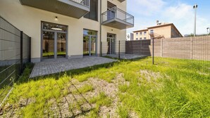 En modern byggnad med ett platt tak, stora fönster och ett plattbelagt entréområde.