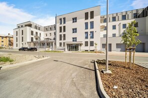 Ein modernes Gebäude mit flachem Dach, zahlreichen Fenstern und einem geschlossenem Eingangsbereich.