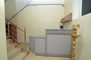 Una escalera con barandillas metálicas, un aplique en la pared y un objeto dorado decorativo.