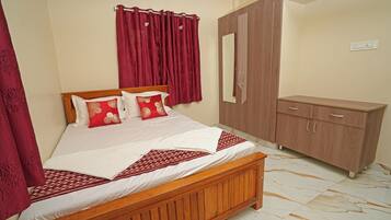 A bedroom with a wooden bed, red curtains, a wardrobe, and a mirror.