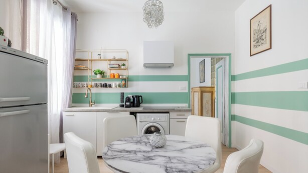 A compact kitchen with a washing machine, a coffee maker, and a sink. - Casa 3 Frecce a Corte Isolani by Wonderful Italy (Bologna)
