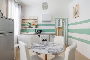 A compact kitchen with a washing machine, a coffee maker, and a sink. - Casa 3 Frecce a Corte Isolani by Wonderful Italy (Bologna)
