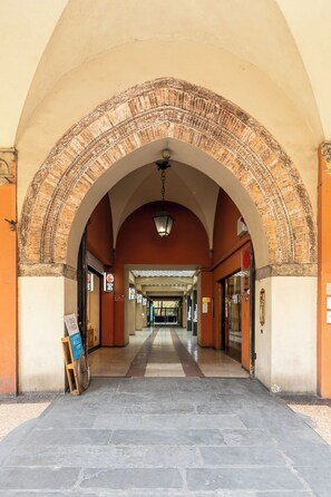 A corridor with a tiled floor, an arched brick ceiling, and a hanging light fixture. - Casa 3 Frecce a Corte Isolani by Wonderful Italy (Bologna)
