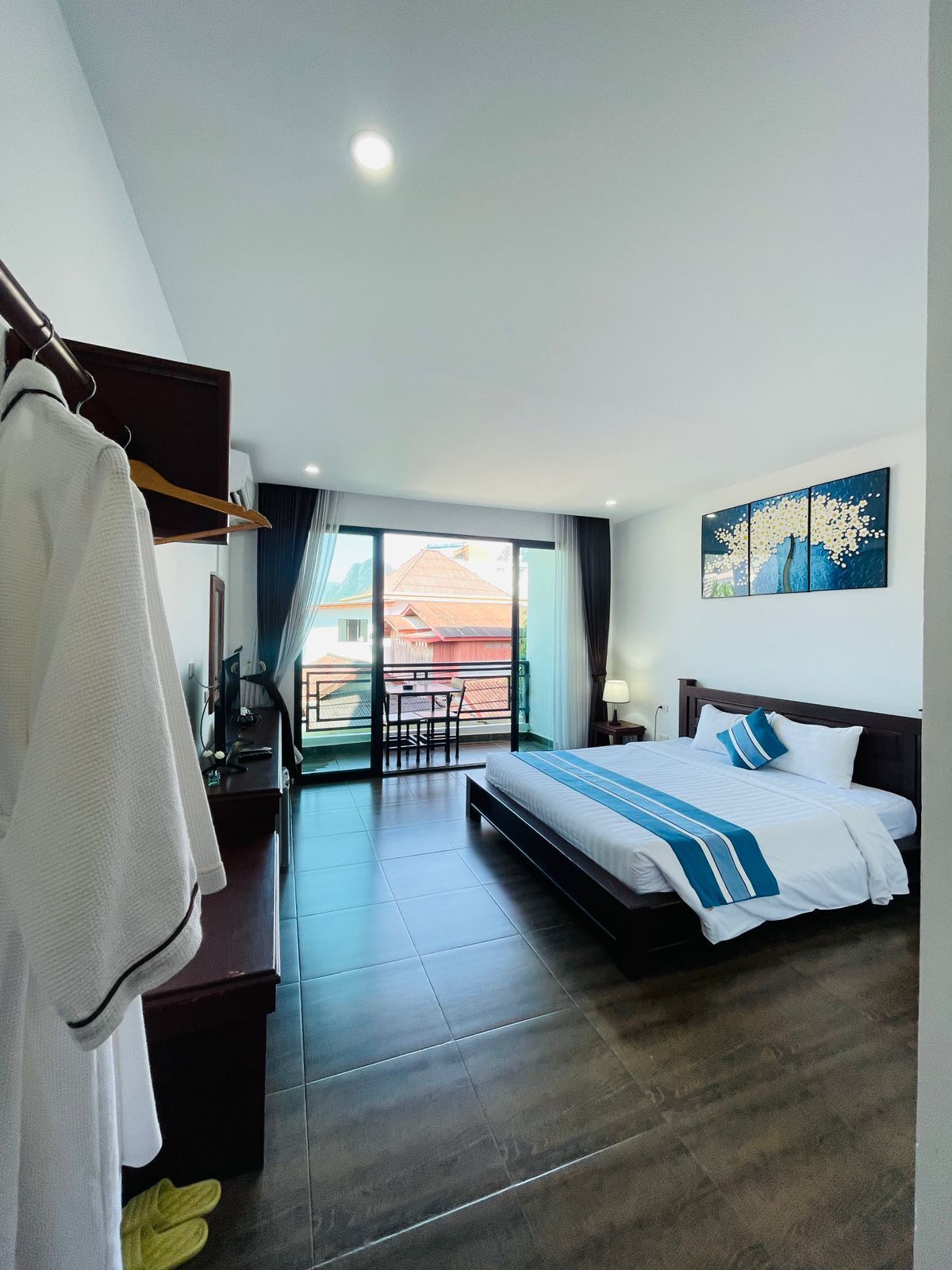 Una habitación de hotel con cama, escritorio, silla y vistas al exterior.