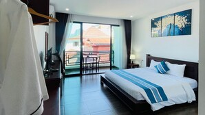 Una habitación de hotel con cama, escritorio, silla y vistas al exterior.
