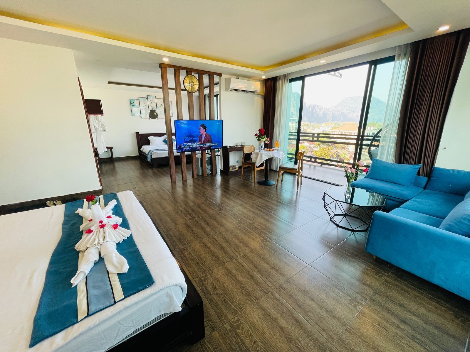 Ein Hotelzimmer mit Bett, einer Sitzecke, einem Fernseher und einem Balkon mit Blick.