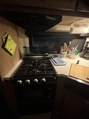 A compact kitchen with a stove, a microwave, and a small countertop. - In the country Fishing hunting boating kayaking. (Mercer)