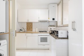 A modern kitchen with white cabinetry, a built-in oven, a microwave, and a kettle. - Apartment 'La Chicca Nel Barocco' with Balcony, Wi-Fi, and Air Conditioning (Modica)