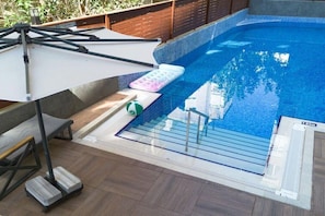 A swimming pool with a sun lounger, a step stool, and a floating mat. - Vega City Apart Hotel (Alanya)