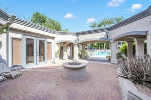 A courtyard with a pool, outdoor seating, and a fire pit.