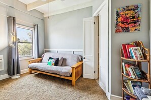 Ein Zimmer mit einem Bett, einem Bücherregal und einem Fenster.