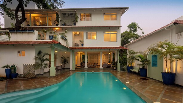 Una casa de dos pisos con piscina en el patio.