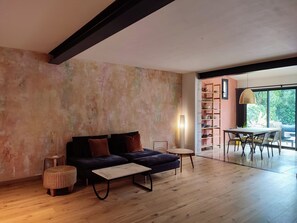 Ein modernes Wohnzimmer mit einer Couch, einem Couchtisch und einem Essbereich mit Tisch und Stühlen.