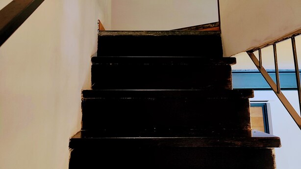 Una escalera con barandilla y rellano.