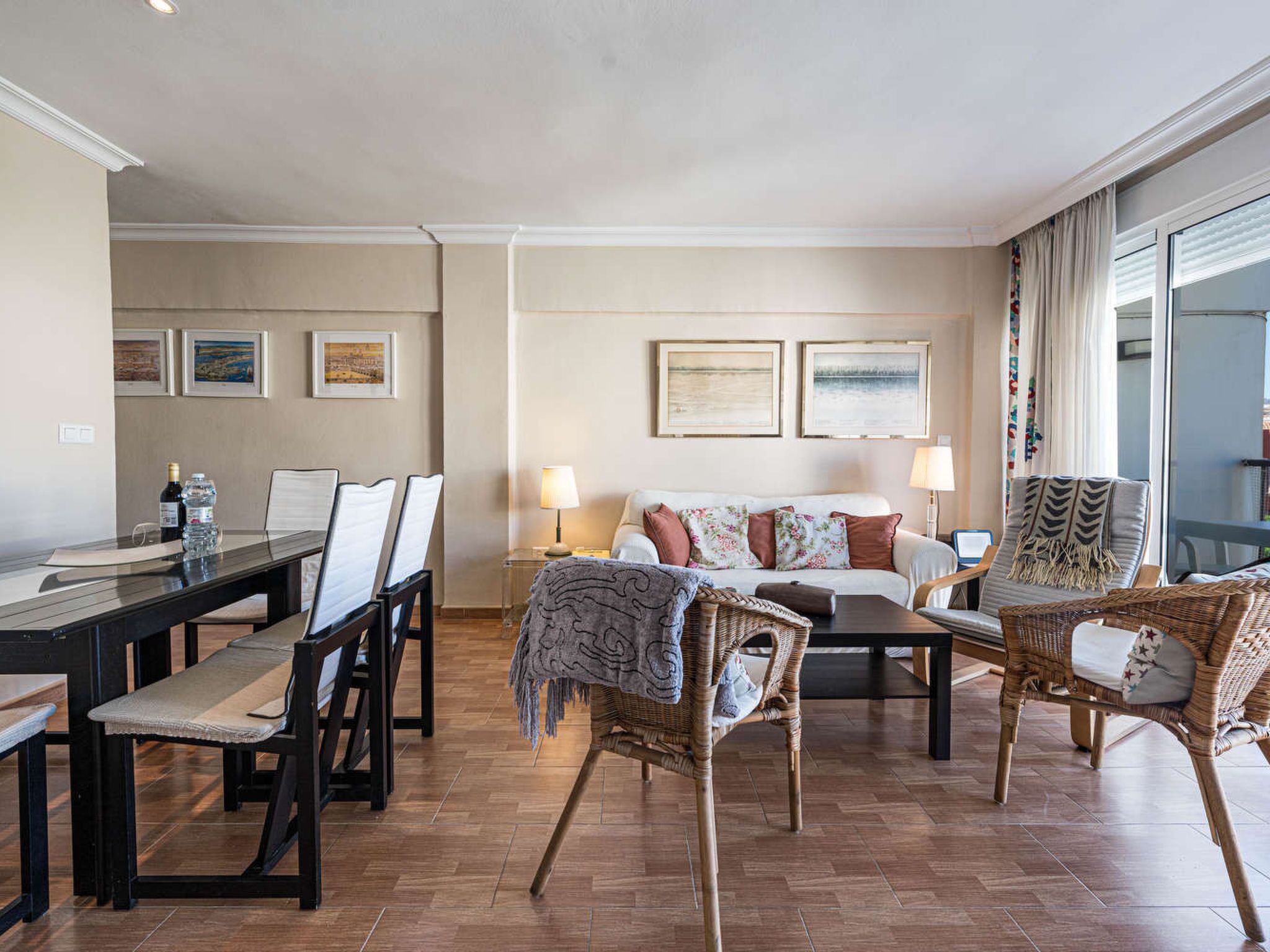 Un salon spacieux comprenant un coin repas, un ensemble de canapés et une grande fenêtre.