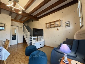 A living room with a wooden ceiling, a TV, a sofa, and a lamp. - Lou Pignada—Veranda, private garden—bicycles available, and the beach is 6 minutes away (Mimizan)