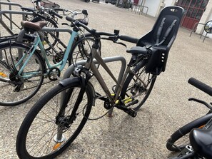 A bicycle parked in a gravel area with a metal rack. - Lou Pignada—Veranda, private garden—bicycles available, and the beach is 6 minutes away (Mimizan)
