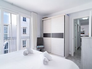 A hotel room with a bed, a chair, a wardrobe, and a balcony. - Apartment  by Interhome (Nerja)