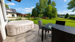 A patio area with a mattress, a table, and chairs.