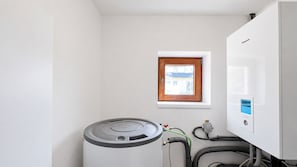 Una habitación con calentador de agua, ventana y panel de control.