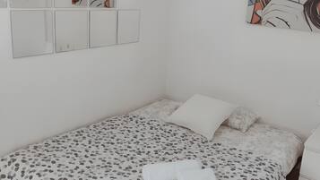 Un dormitorio con una cama, una mesita de noche y obras de arte en la pared.