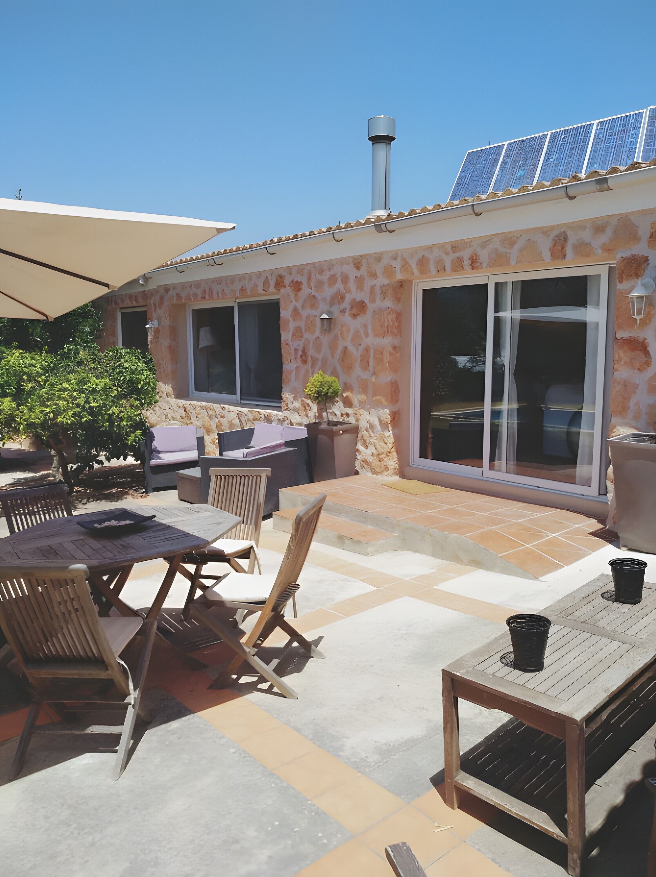 Un'area patio con mobili da esterno, un tavolo e una pianta in vaso.