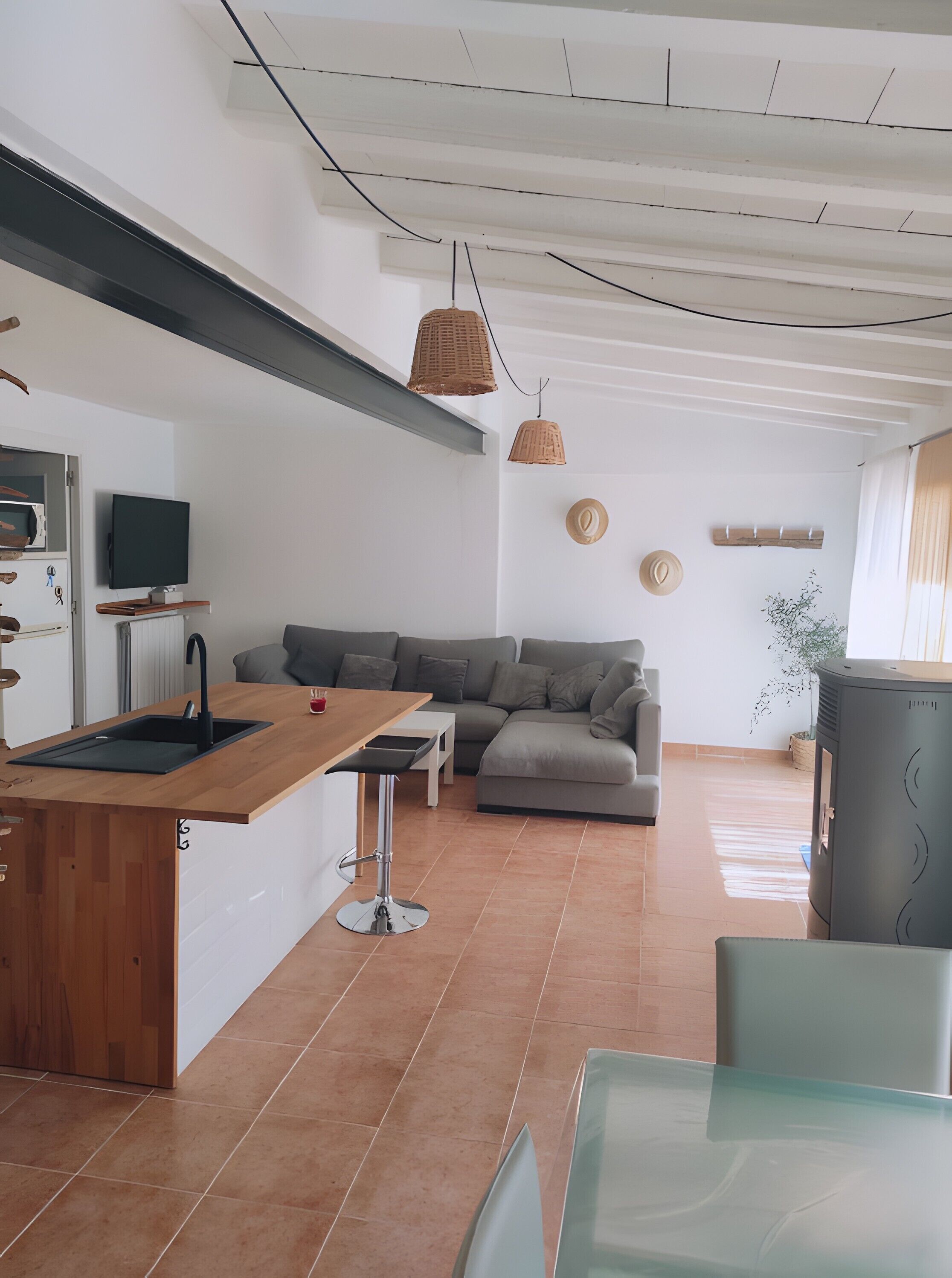Una cucina moderna con piano di lavoro in legno, lavello incassato e rubinetto nero.