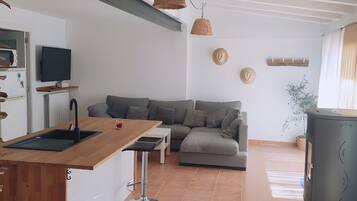 Una cucina moderna con piano di lavoro in legno, lavello incassato e rubinetto nero.