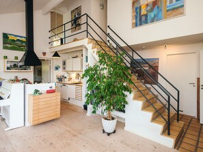 A spacious living area with a staircase, a dining area, and a kitchen. - 4 Star Holiday Home in Knebel (Knebel)