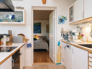 A compact kitchen with a wooden countertop, a coffee machine, and a sink. - 4 Star Holiday Home in Knebel (Knebel)