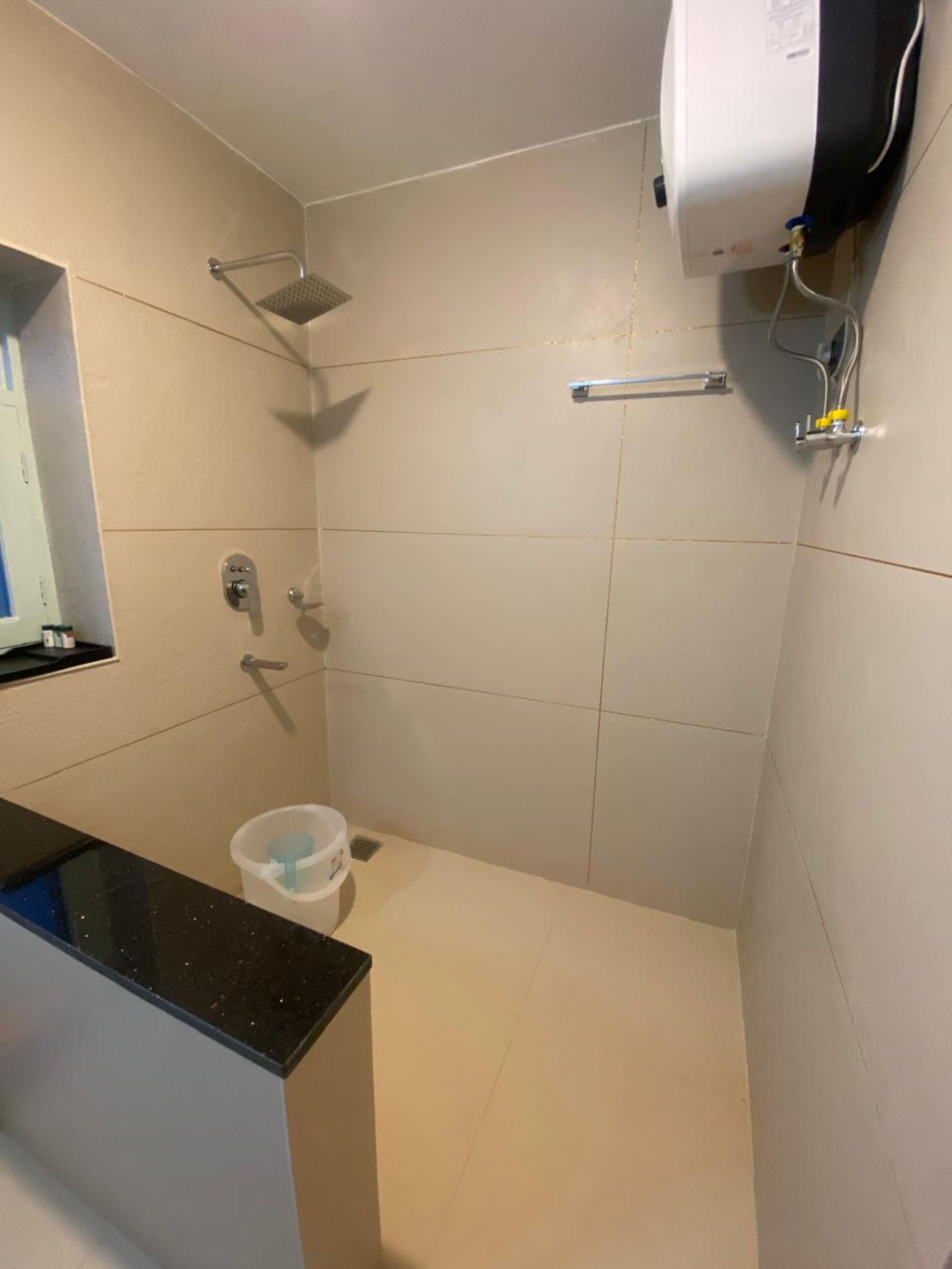 A small, tiled bathroom with a shower, a toilet, and a sink.