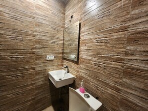 A bathroom with a sink, mirror, and a soap dispenser. - Oly Hotel Ruhaan Near New Delhi Railway  (New Delhi)