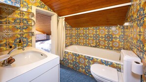 A bathroom with a bathtub, toilet, and sink.