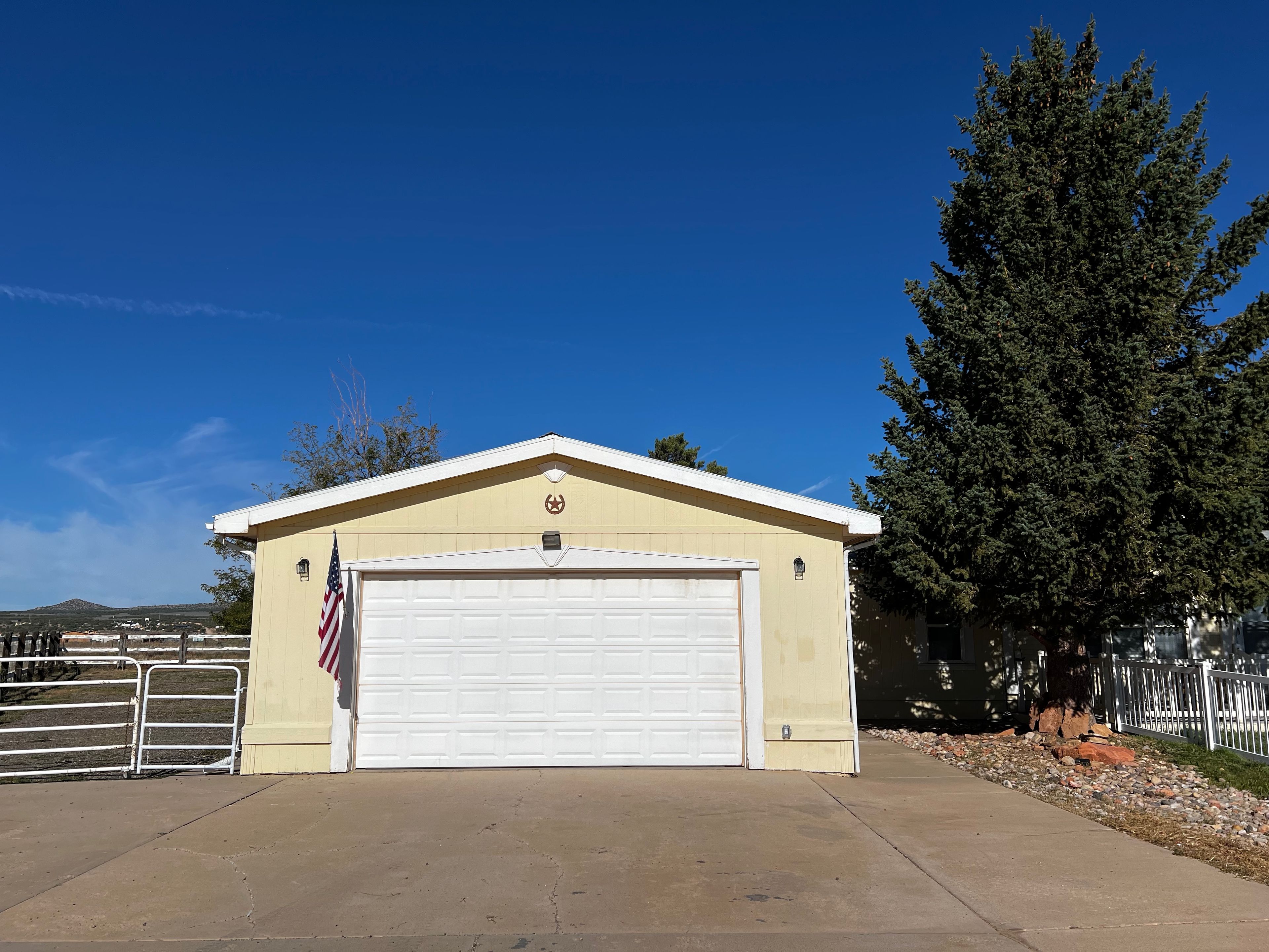 A single-story building with a garage door, an American flag, and a star emblem on the wall.