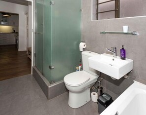 Un baño moderno con inodoro, lavabo y ducha.