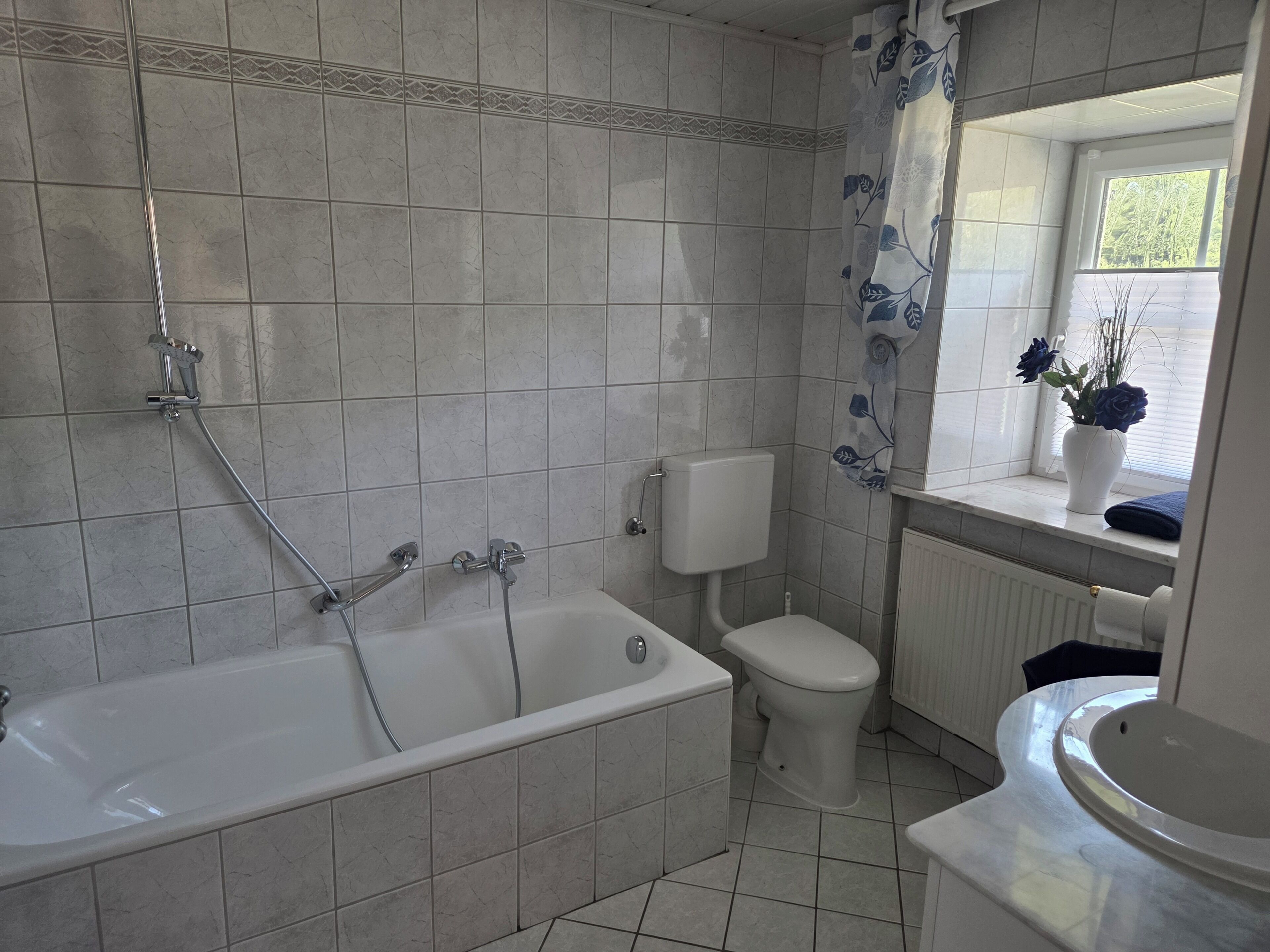 A bathroom with a bathtub, toilet, and sink.