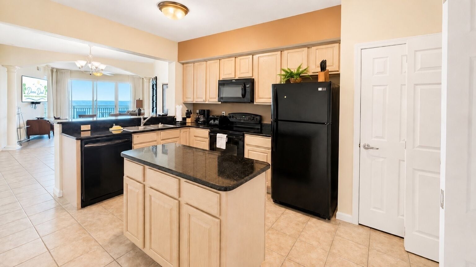 A modern kitchen with a central island, a microwave, a refrigerator, and a sink.