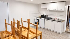 A modern kitchen with white cabinets, a built-in oven, and a coffee machine.