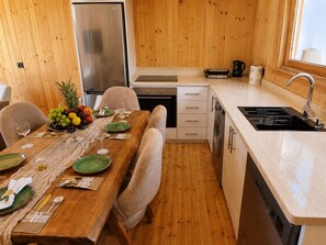 Eine kleine Küche mit Essbereich, Holzboden und einem Edelstahl-Kühlschrank.