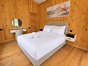 Ein Schlafzimmer mit Holzvertäfelung, einem Bett, einem Nachttisch, einem Spiegel und einem Wandbild.