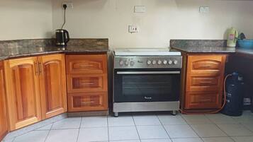 A kitchen with wooden cabinets, a gas stove, and a coffee maker.