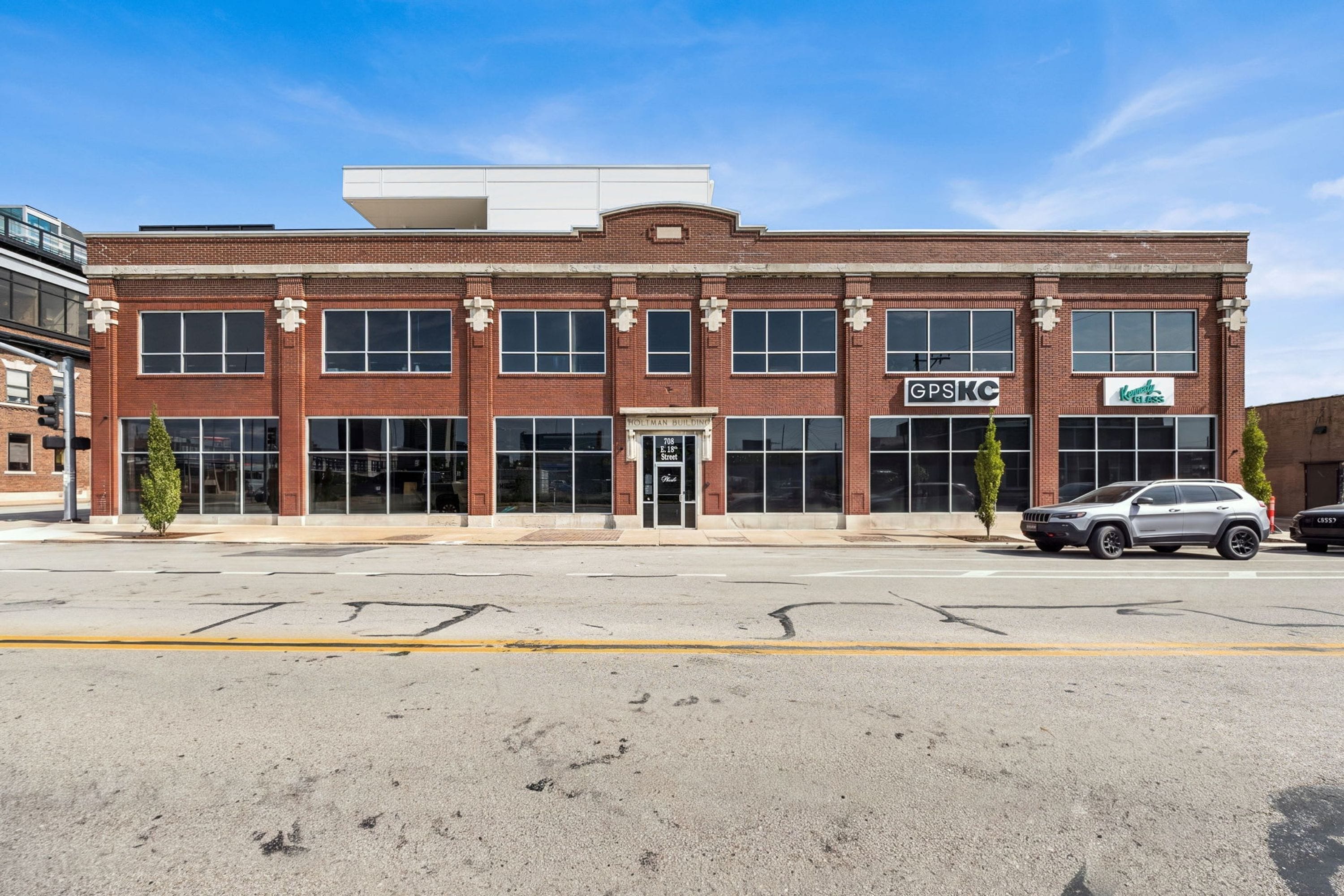 A red brick building with large windows and a flat roof.