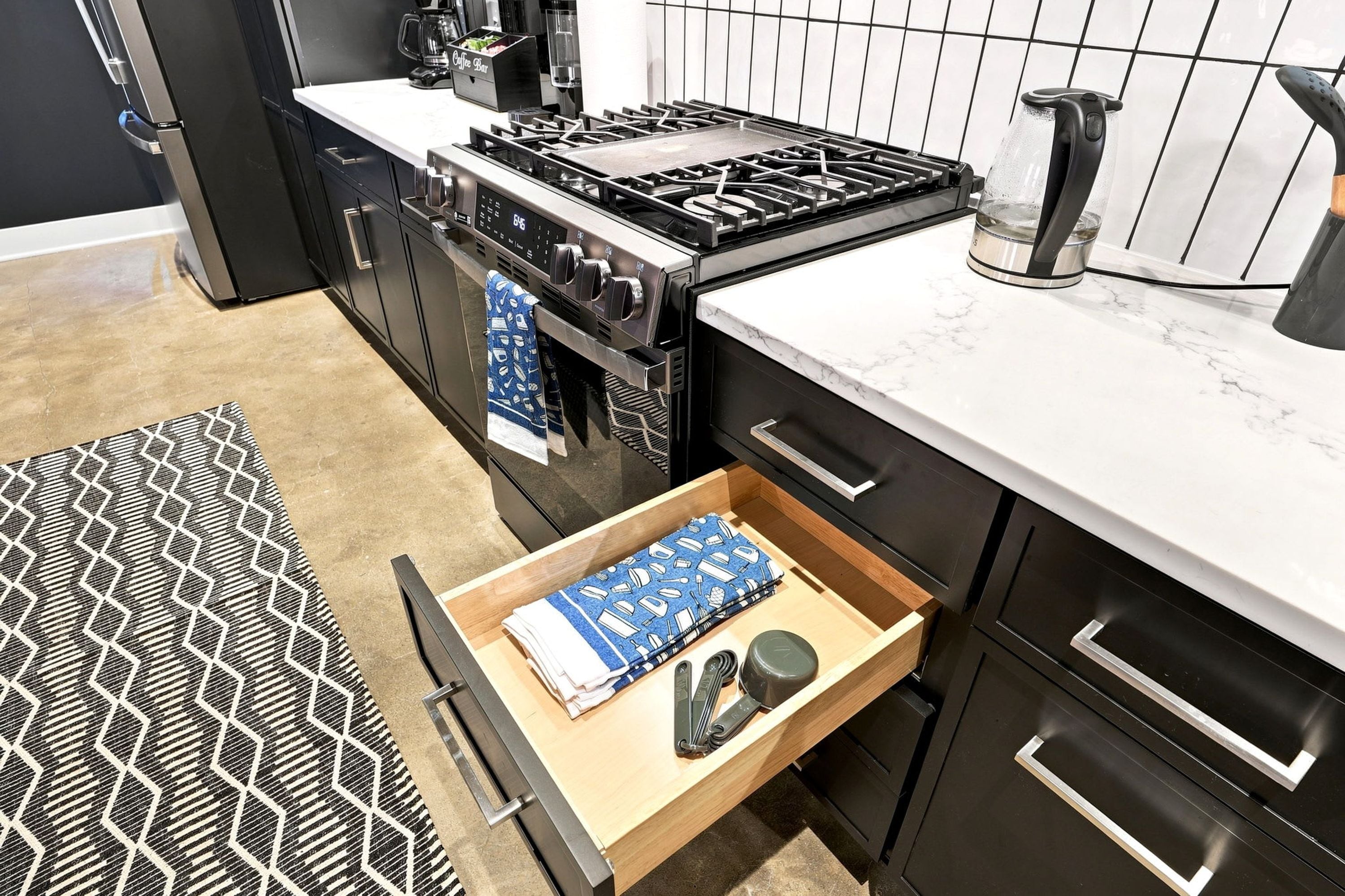 Une cuisine moderne équipée d’une cuisinière, d’un four et d’une machine à café intégrés.