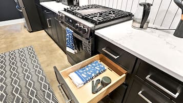 A modern kitchen with a built-in stove, oven, and coffee maker.