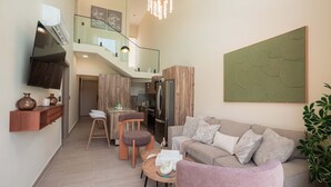 A modern living room with a sofa, coffee table, and a dining area with a kitchen in the background. - NOK Modern 3BR Townhouse in Punta Cana (Punta Cana)