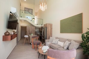 A modern living room with a sofa, coffee table, and a dining area with a kitchen in the background. - NOK Modern 3BR Townhouse in Punta Cana (Punta Cana)
