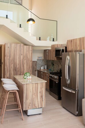 A modern kitchen with a central island, stainless steel appliances, and wooden cabinetry. - NOK Modern 3BR Townhouse in Punta Cana (Punta Cana)