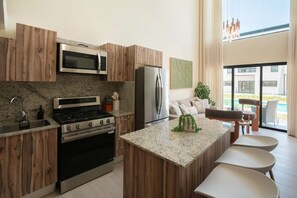 A modern kitchen with granite countertops, stainless steel appliances, and wooden cabinetry. - NOK Modern 3BR Townhouse in Punta Cana (Punta Cana)