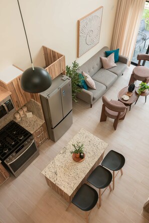 Eine moderne Küche mit Einbauofen, Kühlschrank und Essbereich mit Tisch und Stühlen.